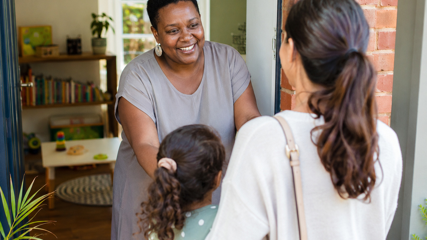 A family receiving a warm welcome from a family day care educator